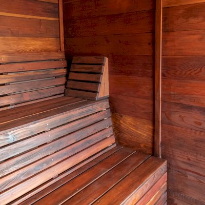 Raul’s Rad Redwood Sauna (Options: 11' W, 8' D, 11' H, California Redwood (for Interiors) & Mature Redwood (for Exteriors), Pitch Roof for Exterior Areas, "L" Shape Bench (2 levels), Transparent Premium Sealant).