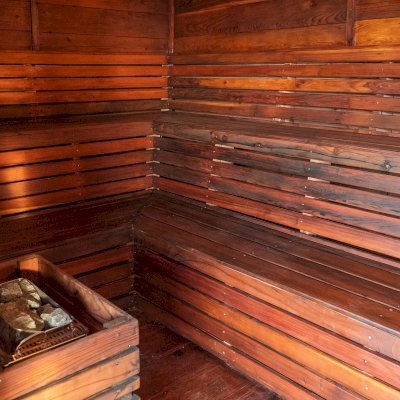 Raul’s Rad Redwood Sauna (Options: 11' W, 8' D, 11' H, California Redwood (for Interiors) & Mature Redwood (for Exteriors), Pitch Roof for Exterior Areas, "L" Shape Bench (2 levels), Transparent Premium Sealant).