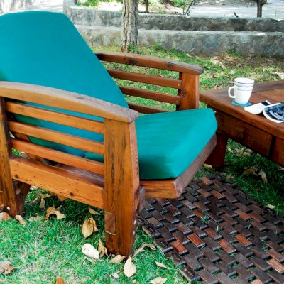 Reclining Redwood Easy Chair (Options: Old-Growth Redwood, 4" Cushion, Transparent Premium Sealant). Photo shows easy chair in reclined position with Flexible Floor Mat (Mature Redwood with Coffee Stain) and Coffee Table (Old-Growth Redwood with Transparent Premium Sealant).