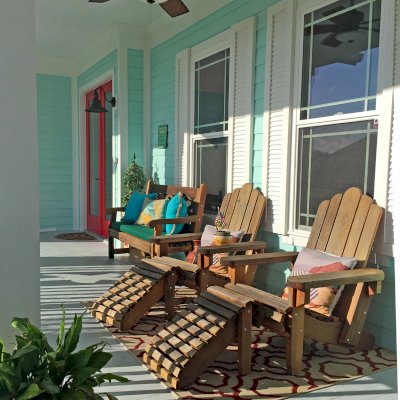 Redwood Adirondack Chair with Ottomans (Options: Standard Size, Redwood, No Cushion, Transparent Premium Sealant). When photographed the finish was 3 years old. Photo also shows a Hennell bench in the background. Photo Courtesy of L. Davies of The Villages, Florida.