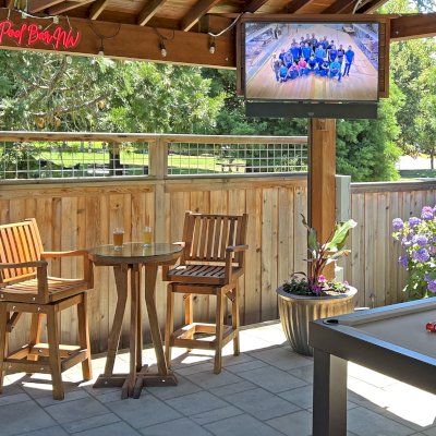 Redwood Cocktail Bar Stools (Options: Mature Redwood, Arms, Swivel Seat, 23" H, No Cushion, Transparent Premium Sealant). Photo Also Shows a Round Cocktail Table and a Del Norte Pavilion.