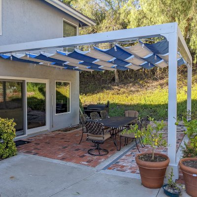 Retractable Canopy Pergola (Options: 16' L x 16' W, Attached to Wall by Custom Request, No Privacy Panel, Mosaic Redwood, 9.5 ft Post Height, No Electrical Wiring Trim,  2-Post Anchor Kit for Concrete, No Post Decorative Trim, No Ceiling Fan Base, No Curtain Rods, Off-White Oil-Based Primer). Photo Courtesy of J. Mebane of San Diego, California.