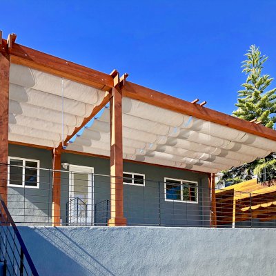 Retractable Canopy Pergola (Options: 30' L x 12' W, No Privacy Panel, Mature Redwood, 8 x 8 Posts by Custom Request, 10 ft Post Height, No Electrical Wiring Trim, Post Anchor Kit for Concrete, No Post Decorative Trim, No Ceiling Fan Base, No Curtain Rods, Transparent Premium Sealant, Overhang of Supports by Custom Request). Photo Courtesy of J. Herr of Venice, CA.
