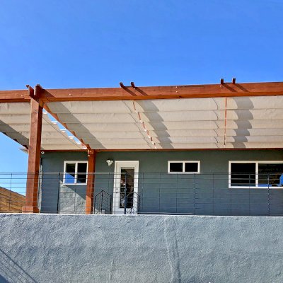 Retractable Canopy Pergola (Options: 30' L x 12' W, No Privacy Panel, Mature Redwood, 8 x 8 Posts by Custom Request, 10 ft Post Height, No Electrical Wiring Trim, Post Anchor Kit for Concrete, No Post Decorative Trim, No Ceiling Fan Base, No Curtain Rods, Transparent Premium Sealant, Overhang of Supports by Custom Request). Photo Courtesy of J. Herr of Venice, CA.