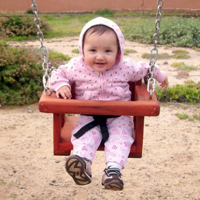 Toddler/Small Rory's Big Playground Swing Sets  (Options: Mature Redwood, Transparent Premium Sealant).  This swing is being enjoyed by eight-month-old Norma Mia.  Toddler's swing seats are sized for kids up to age 5.