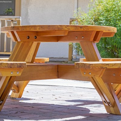 Round Wooden Picnic Table (Attached Benches) (Options: 4' Diameter, Attached Benches, Mosaic Douglas-Fir, Standard Tabletop, No Lazy Susan, No Umbrella Hole, Transparent Premium Sealant). Photo courtesy of Vanguard University [55 Fair Dr, Costa Mesa, CA].