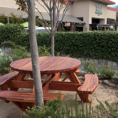 Round Wooden Picnic Tables (Attached Benches) (Options: 5' Diameter, Attached Benches, Mosaic Redwood, Standard Tabletop, No Lazy Susan, Umbrella Hole & Plug, Transparent Premium Sealant). Photo Courtesy of Whole Foods Market of San Rafael, CA.