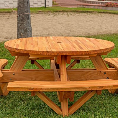 Round Wooden Picnic Table (Attached Benches) (Options: 5' Diameter, Attached Benches, Mosaic Douglas-Fir, Standard Tabletop, No Lazy Susan, 2" Umbrella Hole, Transparent Premium Sealant). Photo courtesy of El Estero Beach Resort in Ensenada, Mexico.