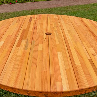 Round Wooden Picnic Table (Attached Benches) (Options: 5' Diameter, Attached Benches, Mosaic Douglas-Fir, Standard Tabletop, No Lazy Susan, 2" Umbrella Hole, Transparent Premium Sealant). Photo courtesy of El Estero Beach Resort in Ensenada, Mexico.