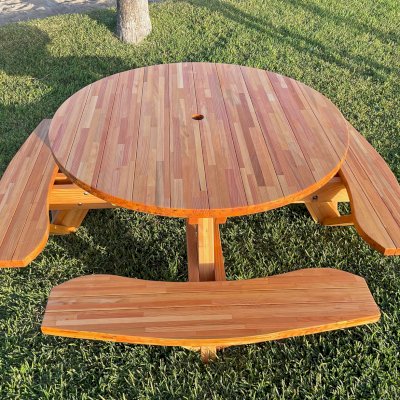Round Wooden Picnic Table (Attached Benches) (Options: 5' Diameter, Attached Benches, Mosaic Douglas-Fir, Standard Tabletop, No Lazy Susan, 2" Umbrella Hole, Transparent Premium Sealant). Photo courtesy of El Estero Beach Resort in Ensenada, Mexico.