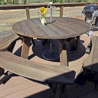 Round Wooden Picnic Table (Detached Benches) (Options: 4.5' Diameter, Unattached Benches, California Redwood, Round Picnic Bench, Standard Tabletop, No Lazy Susan, 2" Umbrella Hole, Transparent Premium Sealant). Photo Taken A Few Years After Installation. Photo Courtesy of S. Risso of Lewiston, CA.