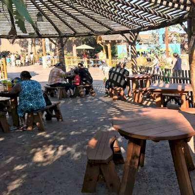 Round Wooden Picnic Tables with Picnic Benches Installed in Knott's Berry Farm in Buena Park, California. Photo Also Shows Some Square Patio Table Sets with Benches.