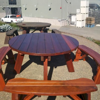 In 2017, the Hobbs Winery in Sebastopol called us to say that one of the two Old-Growth Redwood table sets they had purchased from us in 2003 had been damaged by a truck. We picked it up and rebuilt and refinished it. When we placed it next to the old table that is now 14 years, we got this picture that perfectly highlights how Redwood holds up over the decades without any maintenance. It just darkens as the table set in the rear shows, but it remains perfectly useable
