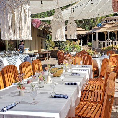 San Francisco Redwood Patio Table (Options: 12' L, 46" W Tabletop, Chairs, Mosaic Eco-Wood, 12 Chairs, Luna Chair Design, 2 Armchairs & Side Chairs, No Cushions, Standard Tabletop, Slightly Rounded Corners, No Umbrella Hole, Transparent Premium Sealant). Photo Also Shows 2 Round Patio Table Sets in Background. Photo Courtesy of J. Newman of Carmel Valley, CA.