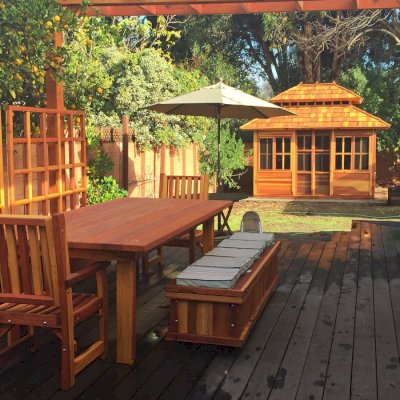 San Francisco Redwood Patio Table (Options: 8' L, 46"W Tabletop,End Armchairs, California Redwood, 2 Ruth Chairs, Standard Tabletop, Squared Corners, No Umbrella Hole, Transparent Premium Sealant). Photo Also Shows a Storage Bench, Dream Gazebo and Some Mendocino Planters with Trellises. Photo Courtesy of Tina Phi of Palo Alto, CA.