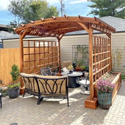 Small Arched Pergola Kits (Options: 12' L x 12' W, 2 Privacy Panels [Custom trellis], California Redwood, No Rain Guard, 9 ft Post Height, No Electrical Wiring Trim, No Decorative Trim, 4-Post Anchor kit for Concrete, No Curtain Rods, No Retractable Shade Canopy, Transparent Premium Sealant). Photo Also Shows Some Napa Planters Around the Pergola. Photo Courtesy of J. Bishop of St. Louis, Missouri.
