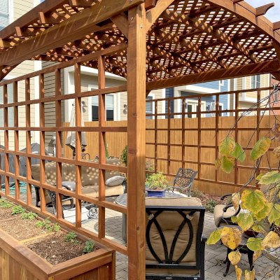 Small Arched Pergola Kits (Options: 12' L x 12' W, 2 Privacy Panels [Custom trellis], California Redwood, No Rain Guard, 9 ft Post Height, No Electrical Wiring Trim, No Decorative Trim, 4-Post Anchor kit for Concrete, No Curtain Rods, No Retractable Shade Canopy, Transparent Premium Sealant). Photo Also Shows Some Napa Planters Around the Pergola. Photo Courtesy of J. Bishop of St. Louis, Missouri.