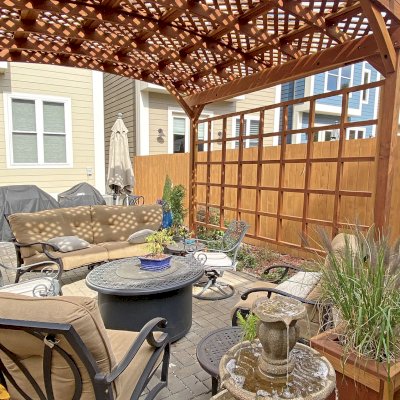 Small Arched Pergola Kits (Options: 12' L x 12' W, 2 Privacy Panels [Custom trellis], California Redwood, No Rain Guard, 9 ft Post Height, No Electrical Wiring Trim, No Decorative Trim, 4-Post Anchor kit for Concrete, No Curtain Rods, No Retractable Shade Canopy, Transparent Premium Sealant). Photo Also Shows Some Napa Planters Around the Pergola. Photo Courtesy of J. Bishop of St. Louis, Missouri.