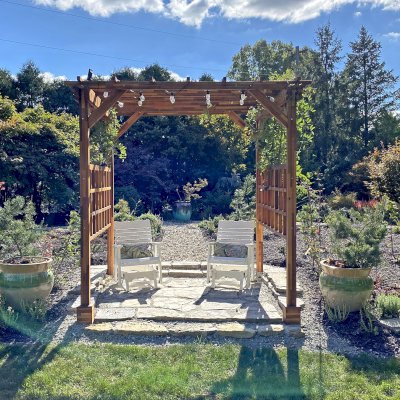 Small Garden Pergola Kit (Options: 9' L x 9' W, Custom Privacy Panels on 2 Sides, Mosaic Redwood, 9 ft Post Height, 6" Overhangs, 4-Post Anchor Kit for Concrete, No Curtain Rods, No Decorative Trims, Transparent Premium Sealant). Photo Courtesy of B. Egbert of Dayton, OH.