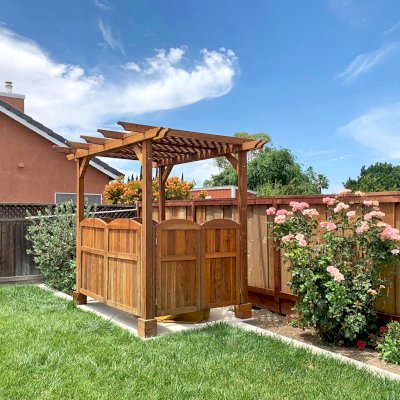 Small Lattice Pergola  (Options: 10' L x 8' W, Custom Gates on 8 ft Side and Custom Panel on the Other Side, California Redwood, No Rain Guard, 8.5 ft Post Height, No Electrical Wiring Kit, No Post Decorative Trim, 4-Post Anchor Kit for Concrete, No Curtain Rods, No Retractable Shade Canopy, Transparent Premium Sealant). Photo Courtesy of C. Malcolm of Tracy, California.