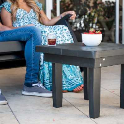 Square Side Table (Options: 23" Size, Mature Redwood, Rounded Corners, 18" H, Black Stain Premium Sealant) with a Massive Rocking Bench.