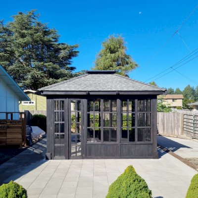 Spa Gazebo Kit (Options: 14' L, 14' W, Douglas-Fir, All Sliding Windows with Screens, 4' x 4' Skylight, 24" H Siding Below Windows, Vertical Siding, French Doors Without Screen, No Flooring, Black Stain Premium Sealant). Photo Courtesy of S. Mortensen of Eureka, CA.
