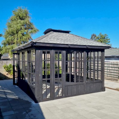 Spa Gazebo Kit (Options: 14' L, 14' W, Douglas-Fir, All Sliding Windows with Screens, 4' x 4' Skylight, 24" H Siding Below Windows, Vertical Siding, French Doors Without Screen, No Flooring, Black Stain Premium Sealant). Photo Courtesy of S. Mortensen of Eureka, CA.