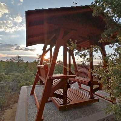 St. Anthony's Face to Face Gliders (Extra Wide, Mature Redwood, With Beverage Armrests, With Kid's Platform, Extra Wide Roof, No Engraving, Transparent Premium Sealant). Photo Courtesy of P. Molina of Marugan, Segovia.