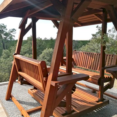 St. Anthony's Face to Face Gliders (Extra Wide, Mature Redwood, With Beverage Armrests, With Kid's Platform, Extra Wide Roof, No Engraving, Transparent Premium Sealant). Photo Courtesy of P. Molina of Marugan, Segovia.