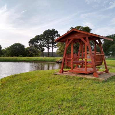 St. Anthony's Face to Face Glider (Options: Standard Roof Size, Old-Growth Redwood, Without Beverage Armrests, No Kid's Platform, Standard Closed Roof, No Engraving, Transparent Premium Sealant). Photo Courtesy of R. Vincent of Wimberly, Texas.