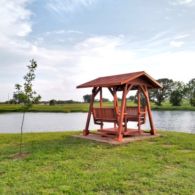 St. Anthony's Face to Face Glider (Options: Standard Roof Size, Old-Growth Redwood, Without Beverage Armrests, No Kid's Platform, Standard Closed Roof, No Engraving, Transparent Premium Sealant). Photo Courtesy of R. Vincent of Wimberly, Texas.