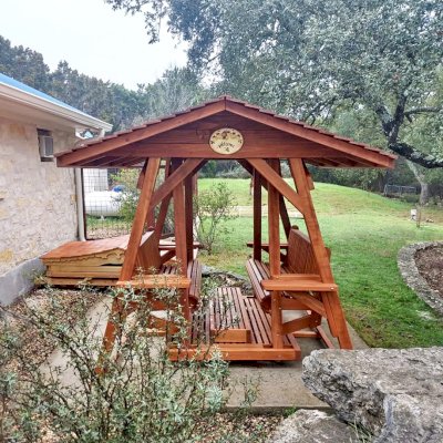 St. Anthony's Face to Face Gliders (Options: Extra Wide Size, Mature Redwood, With Beverage Armrests, No Kid's Platform,  XW Roof, No Engraving, Transparent Premium Sealant). Photo Courtesy of R. Vincent of Wimberly, Texas.