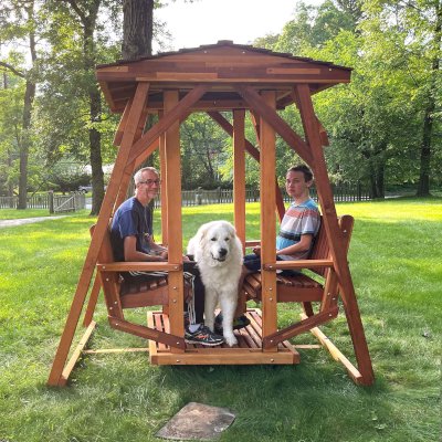 St. Anthony's Face to Face Gliders (Adult Size, Mosaic Redwood, Without Beverage Armrests, No Kid's Platform, Standard Closed Roof, No Engraving, Transparent Premium Sealant). Photo Courtesy of M. Huguenin of Princeton, NJ.
