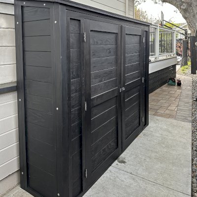 Storage Shed (Options: 7' W x 2' D x 6' H, Douglas-fir, Two Shelves, Inclination of the Roof to Be From Back to Door, Double Doors Opening Out From Center, Black Stain Premium Sealant). Photo Courtesy of L. Rutherford of Los Gatos, CA.