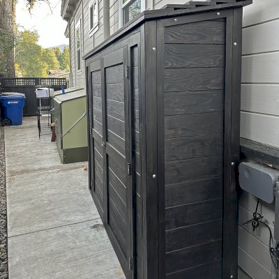 Storage Shed (Options: 7' W x 2' D x 6' H, Douglas-fir, Two Shelves, Inclination of the Roof to Be From Back to Door, Double Doors Opening Out From Center, Black Stain Premium Sealant). Photo Courtesy of L. Rutherford of Los Gatos, CA.