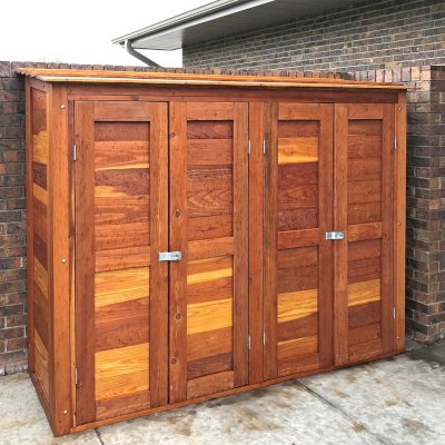 Storage Shed (Options: 8' W, 2' D, 5' H, California Redwood, Double Doors Opening Out From Center, Three Shelves at 18" H, 36" H and 50" H, Hardware Kit for Wood, Transparent Premium Sealant). Photo Taken When Rain Started. Photo Courtesy of J. Foster of Great Bend, Kansas.