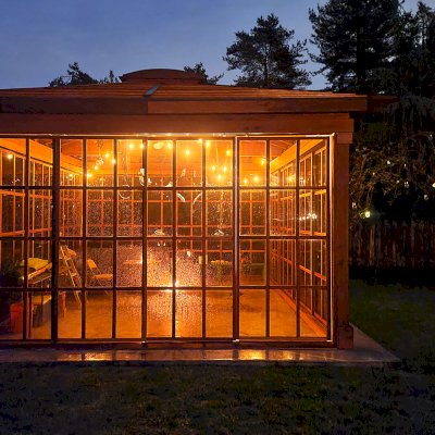 Still Warm and Inviting Even in the Rain. Sun Gazebo with Sliding Doors (Options: 20' L x 16' W, Exterior Skin and Roofing in California Redwood, Rest of Structure Will Be in Douglas-Fir, 9 ft Wall Height, With 4' x 8' Skylight, No Flooring, Standard Wood Roof, Roof with Two Additional Beams to Handle Swing Stresses, Transparent Premium Sealant). Photo Courtesy of R. Huffman of Seattle, WA.