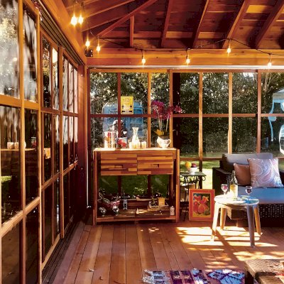 Sun Gazebo with Sliding Doors (Options: Custom Size 16' L x 14' W, California Redwood, 8 ft Wall Height, Without Skylight, Complete Floor, with Metal Roof, Transparent Premium Sealant). Photo Also Shows an Eli's Potting Bench. Photo Courtesy of R. Graham-Helwig of Foster City, California.