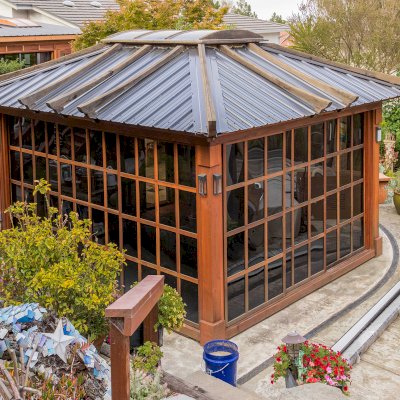 Sun Gazebo with Sliding Doors (Options: 14' L, 12' W, California Redwood, 4' x 6' Skylight, Complete Floor, Transparent Premium Sealant). Metal roof added by custom request. The roof timbers were not resealed and are 4 years old while the rest of the structure was resealed recently. Photo Courtesy of A. Ramon of South San Francisco, CA. Note: Metal Roof provided by Home Depot: 12ft. Classic Rib Steel Roof Panel in Charcoal, Model #2313417, Internet #204255071