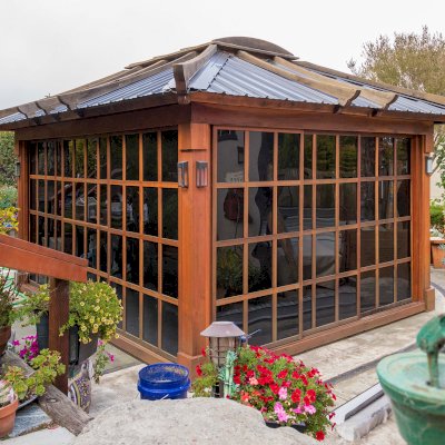 Sun Gazebo with Sliding Doors (Options: 14' L, 12' W, California Redwood, 4' x 6' Skylight, Complete Floor, Transparent Premium Sealant). Metal roof added by custom request. The roof timbers were not resealed and are 4 years old while the rest of the structure was resealed recently. Photo Courtesy of A. Ramon of South San Francisco, CA. Note: Metal Roof provided by Home Depot: 12ft. Classic Rib Steel Roof Panel in Charcoal, Model #2313417, Internet #204255071