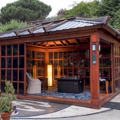 Sun Gazebo with Sliding Doors (Options: 14' L, 12' W, California Redwood, 4' x 6' Skylight, Complete Floor, Transparent Premium Sealant). Metal roof added by custom request. The roof timbers were not resealed and are 4 years old while the rest of the structure was resealed recently. Photo Courtesy of A. Ramon of South San Francisco, CA. Note: Metal Roof provided by Home Depot: 12ft. Classic Rib Steel Roof Panel in Charcoal, Model #2313417, Internet #204255071