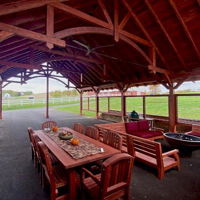Cardinal's Nest Pavilions (Options: 45’ L x 32’ W,  Douglas-fir, 12-Post Anchor Kit for High-Wind, Electrical Wiring Trim Kit for 1 Post, 1 Ceiling Fan Base, Cherry Stain Premium Sealant, with 6 Custom Half Height Louvered Privacy Wall Panels) with a San Francisco Patio Table Set and Custom Kari's Chairs. Photo Courtesy of S. Steckman of East Liverpool, Ohio.