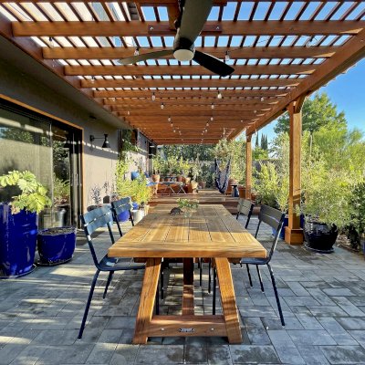 Classic Redwood Patio Table (Options: 6' L x 34 1/2" W, Mature Redwood, No Seating, Old Country Tabletop, Standard, Slightly Rounded Corners, No Umbrella Hole, Transparent Premium Sealant). Table Installed Under an Attached Garden Pergola. Photo Taken 1 Year After Installation. Photo Courtesy of D. Herman of Livermore, CA.