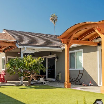 Del Norte Porch Pavilion (Options: 12' L x 16' W, Douglas-fir, 2-Post Anchor Kit for Concrete, No Ceiling Fan Base, No Electrical Wiring Trim Kit, No Post Decorative Trims, Transparent Premium Sealant). Photo also shows a Backyard Porch Pavilion. Photo Courtesy of J. Clark of San Diego, CA.