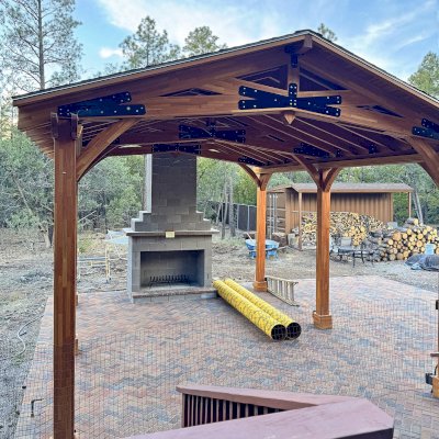 Esther Scissor Truss Pavilion (Options: 22’ L x 18’ W, Mosaic Douglas-Fir, Standard 3/4" T&G Roof Boards, 9.5' H Posts, No Ceiling Fan Base, 6 High-Wind Post Anchors, Cutout to fit Chimney on the Back, Transparent Premium Sealant). Photo Courtesy of H. O'Riley of Lakeside, AZ.