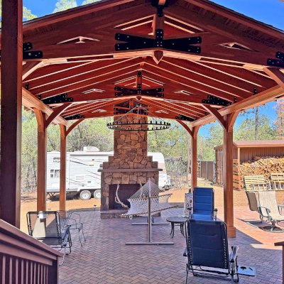 Esther Scissor Truss Pavilion (Options: 22’ L x 18’ W, Mosaic Douglas-Fir, Standard 3/4" T&G Roof Boards, 9.5' H Posts, No Ceiling Fan Base, 6 High-Wind Post Anchors, Cutout to fit Chimney on the Back, Transparent Premium Sealant). Photo Courtesy of H. O'Riley of Lakeside, AZ.
