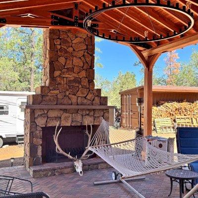 Esther Scissor Truss Pavilion (Options: 22’ L x 18’ W, Mosaic Douglas-Fir, Standard 3/4" T&G Roof Boards, 9.5' H Posts, No Ceiling Fan Base, 6 High-Wind Post Anchors, Cutout to fit Chimney on the Back, Transparent Premium Sealant). Photo Courtesy of H. O'Riley of Lakeside, AZ.
