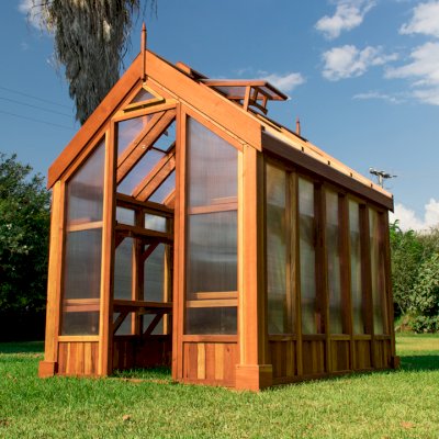 The Forever Hot House (Options: 8 ft L x 6 ft W, California Redwood, 2 shelves long, Transparent Premium Sealant). This Forever Hot House was assembled on a lawn for a photo shoot. We recommend installation be on a developed hardscape of your choosing and not bare soil or lawn.