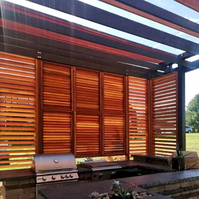 Custom L.A. Modern Pergola (Options: 42' L, 20' W, California Redwood, 10 ft Post Height, Electrical Wiring Trim for 1 Post, 8-Post Anchor Kit for Concrete, 1 Ceiling Fan Base, Rain Guard [3/16" Polycarbonate], Transparent Premium Sealant for Louvers & Rafters and Black Stain for Posts & Supports). Photo Courtesy of L &M Oliverio of Bridgeport, West Virginia.