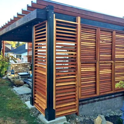 Custom L.A. Modern Pergola (Options: 42' L, 20' W, California Redwood, 10 ft Post Height, Electrical Wiring Trim for 1 Post, 8-Post Anchor Kit for Concrete, 1 Ceiling Fan Base, Rain Guard [3/16" Polycarbonate], Transparent Premium Sealant for Louvers & Rafters and Black Stain for Posts & Supports). Photo Courtesy of L &M Oliverio of Bridgeport, West Virginia.